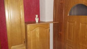 a vase sitting on top of a wooden cabinet next to a door at Le moulin des automates in Fréland