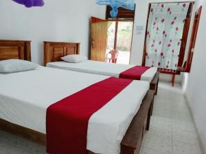 a couple of beds in a room with a window at Jayaru Guest House in Polonnaruwa