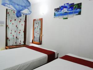 a room with two beds and a window at Jayaru Guest House in Polonnaruwa