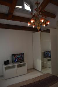 ein Wohnzimmer mit einem Kronleuchter und einem TV in der Unterkunft Yellow House in Venedig