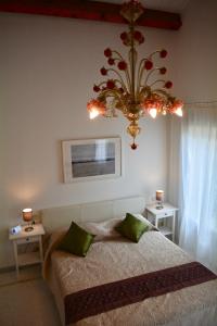 ein Schlafzimmer mit einem großen Bett und einem Kronleuchter in der Unterkunft Yellow House in Venedig