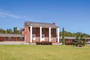 WalhallaRodeway Inn & Suites Walhalla的前面有草场的红砖建筑