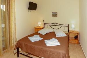 1 dormitorio con 1 cama con 2 toallas en Maria - Pavlos Studios and Apartments en Vourvourou