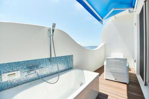 a bathroom with a bath tub with blue tiles at Wakanoura Nature Resort Epicharis in Wakayama +83 photos