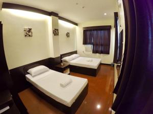 a small room with two beds and a shower at Z Pension in Dumaguete