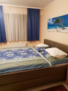 1 dormitorio con 2 camas y cortinas azules en Gartenpension Prosl en Viena