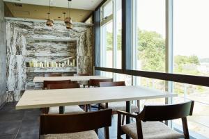 a dining room with tables and chairs and windows at Wakanoura Nature Resort Epicharis in Wakayama
