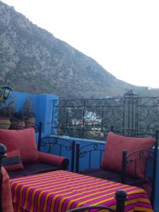 a balcony with two beds and a view of a mountain at Dar Lbakal in Chefchaouen