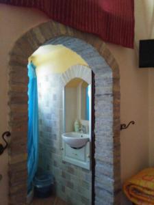 a bathroom with a sink in a brick wall at BB Dimora San Pietro in Ferrandina