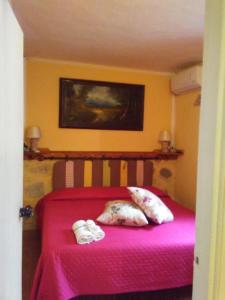 een slaapkamer met een roze bed met twee schoenen erop bij BB Dimora San Pietro in Ferrandina