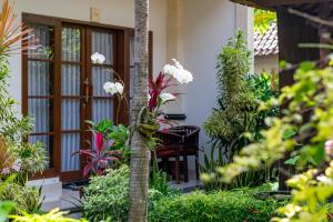 a garden in front of a house with plants at Gatra Ubud Inn in Ubud