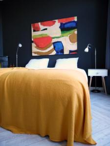 um quarto com uma cama com um cobertor amarelo em Hus em Leeuwarden
