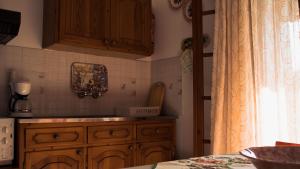a kitchen with wooden cabinets and a counter top at Lefteris Studios in Lefokastro