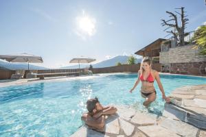 a man and a woman in a swimming pool at Aparthotel Bacher in Bressanone