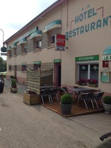 een hotel met stoelen en tafels buiten een gebouw bij Bel Air in Marville