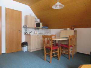 a kitchen with a table and chairs and a microwave at Apartment Dvořáků in Janske Lazne