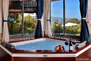a bath tub with a window and a bowl of fruit at Hahar Aatzil in H̱azon