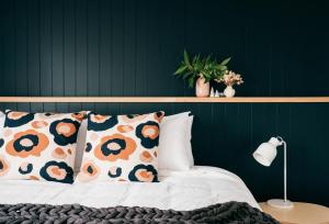 a bedroom with a green wall and a bed with pillows at Laneway Apartments - Orientem in Port Fairy