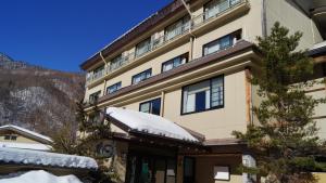a building with snow on top of it at Tabist Kazeyuki in Takayama