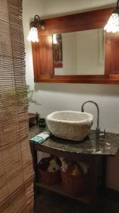a bathroom sink with a large stone bowl on a counter at Residenza al Gelso in Marsala