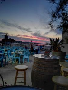 a group of tables and chairs with a sunset in the background at Residenza al Gelso in Marsala