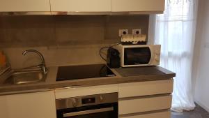 a kitchen counter with a microwave and a sink at Varenna Sweet Home in Varenna +30 photos