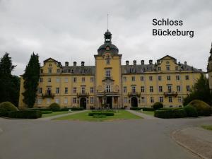 a large yellow building with a clock tower on top at Pension Ramser in Lindhorst