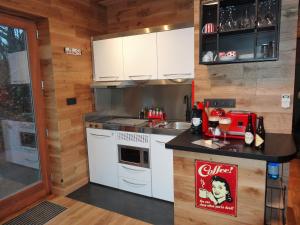 una pequeña cocina con armarios blancos y encimera en La mignonne des fagnes en Malmedy