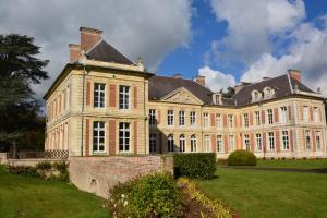 a large brick building with a large yard at Maison de l'horloge in Courcelles-sous-Moyencourt