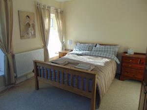 a bedroom with a bed with a dresser and a window at 5 bed cottage in welsh valleys in Rhondda