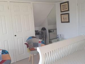 a bedroom with a bed and a chair and a door at Telscombe Cliffs Bed and Breakfast in Rottingdean