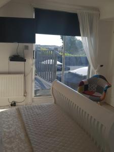 a bedroom with a bed and a view of a balcony at Telscombe Cliffs Bed and Breakfast in Rottingdean