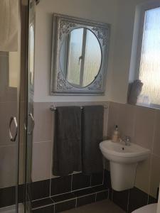 a bathroom with a sink and a mirror at Telscombe Cliffs Bed and Breakfast in Rottingdean