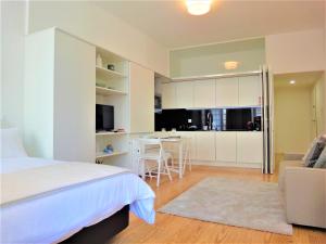 ein Schlafzimmer mit einem Bett und eine Küche mit einem Tisch in der Unterkunft Tiles Apartments in Porto