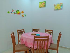 a dining room table with a pink table cloth at Sky Mirror Homestay in Kuala Selangor