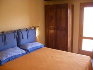 um quarto com uma cama com uma cabeceira azul e uma janela em Casa Nel Corso em Castellammare del Golfo