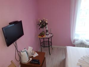 ein Wohnzimmer mit einem TV und einem Tisch in der Unterkunft Hotel Megapolis in Nischni Nowgorod