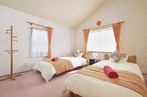 Un dormitorio con dos camas y una ventana. en Villent Fujimi Hiekawa, en Izu