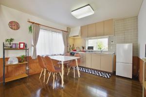 una cucina con tavolo, sedie e frigorifero di Villent Fujimi Hiekawa a Izu