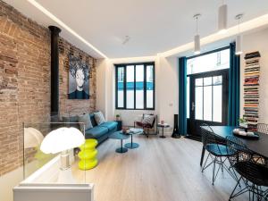 a living room with a blue couch and a brick wall at Exclusive Loft in Le Marais with AC in Paris