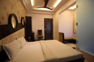 a bedroom with a bed and a clock on the wall at Hotel Navi Mumbai in Navi Mumbai