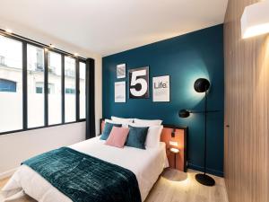 パリにあるExclusive Loft in Le Marais with ACの青い壁のベッドルーム1室(ベッド1台付)