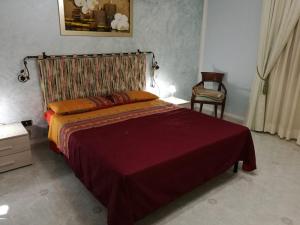 a bedroom with a large bed and a chair at Sant'Andrea in Tricase