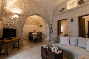 ein Wohnzimmer mit Sofa und Tisch in der Unterkunft Trulli Angela in Locorotondo