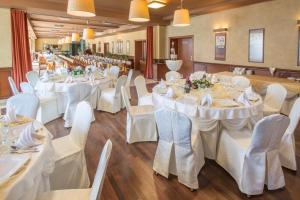 a banquet hall with white tables and white chairs at Business Hotel Vega Wrocław in Wrocław