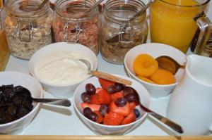 una mesa cubierta con tazones de fruta y yogur en The Bakehouse B&B en Seahouses