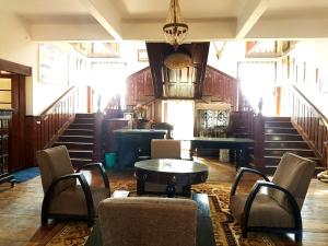 a room with chairs and a table and stairs at Rani Kothi Heritage Residency in Darjeeling