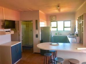 a kitchen with a counter and some stools in it at Dolphin's Nook in Great Brak River