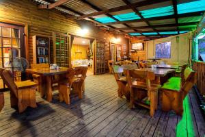 un ristorante con pavimenti e tavoli in legno e sedie di The Spotted Grunter Resort a Port St Johns