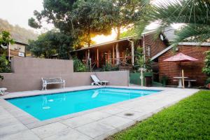 a swimming pool in front of a house at The Spotted Grunter Resort in Port St Johns